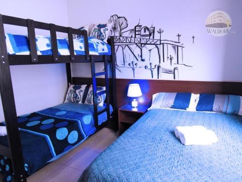 1 dormitorio con 2 literas y lámpara en Residencial Waldorf, en Lima