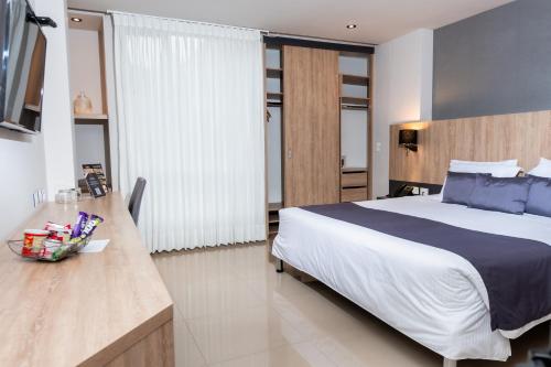 a bedroom with a large bed and a table with a bowl on it at Hotel Plaza del Lili in Cali