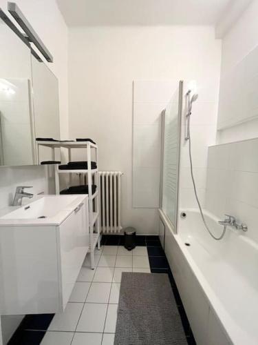 a white bathroom with a shower and a sink at Amazing flat-Center of Brussels in Brussels