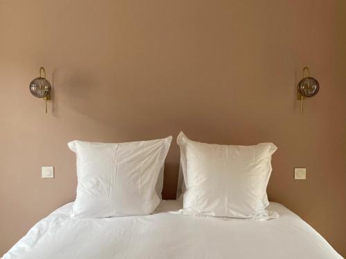 two white pillows sitting on a bed in a bedroom at La Belle Vicoise in Vic-sur-Aisne