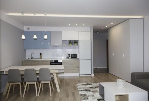 a kitchen and living room with a table and chairs at Baltic View Apartment in Dziwnówek