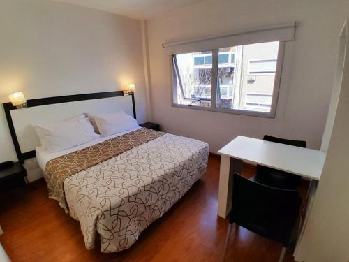 1 dormitorio con cama, mesa y ventana en Edificio Recoleta en Buenos Aires