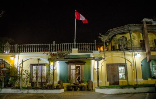 a building with a flag on top of it at night at Hotel & Hacienda El Carmelo in Ica