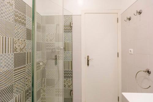 a bathroom with a shower with a glass door at BELEM PLACE - free parking area in Lisbon