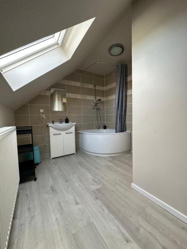 a bathroom with a tub and a sink and a shower at The 75 renovated work or holiday home in Comines