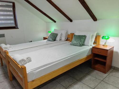 a large bed with white sheets and pillows on it at Apartmani Todorovic in Vinci