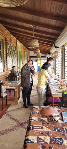 a group of people standing around a table in a restaurant at SHADOW MASK BUNGALOW in Pattipola