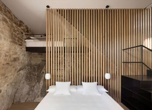 una camera con un letto bianco e una parete in legno di Cabana La Roca a La Roca