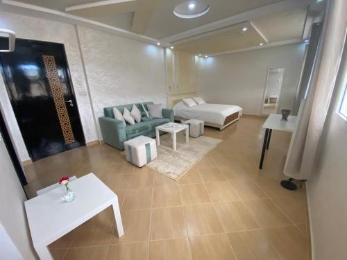 a living room with a green couch and a table at GUITAR PALACE - Chambres d'hôtes in Bni Quolla