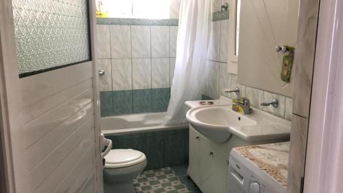 a white bathroom with a sink and a toilet at Blue Paradise Apartment in Lukovë