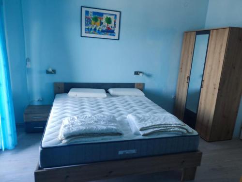 a bed in a room with a blue wall at Apartman Dragica S1 in Pašman