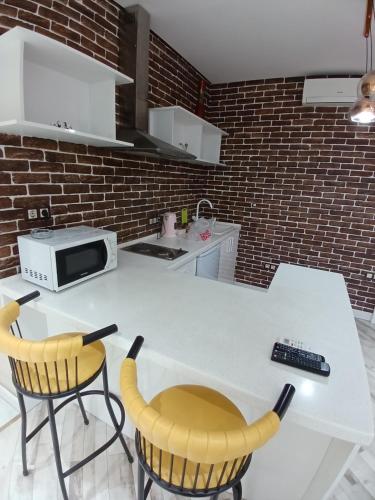 TurksibにあるЖК "Радужный" Аэропорт 1 комнатнаяのキッチン(白いテーブル、黄色い椅子2脚付)