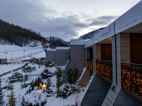 un edificio con una pista de esquí en la nieve en Alpesmith - Bike & Ski apartments, en Bardonecchia