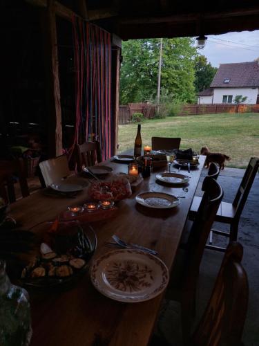 una larga mesa de madera con platos de comida. en Camp Warmia, en Stare Kawkowo
