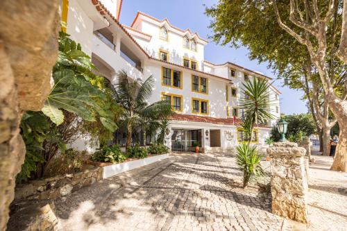 an exterior view of a large white building at Clube do Lago Hotel in Estoril