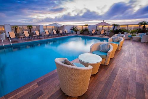 a large swimming pool with chairs and a hotel at Mövenpick Hotel Casablanca in Casablanca