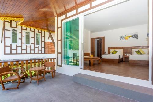 a room with a balcony with a living room at Aura Samui Best Beach Hotel - SHA Plus in Lamai