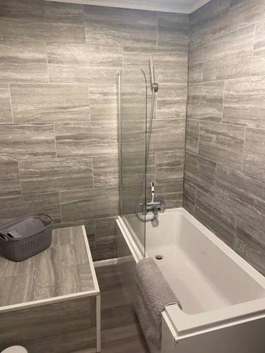 y baño con bañera, mesa y ducha. en Cosy 1 Bed Home @Stevenage, en Shephall