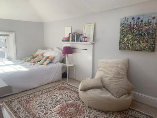 1 dormitorio con 1 cama, 1 silla y 1 alfombra en Top Floor. Top Notch. Tranquil Treat. Stone's throw from Thames., en Maidenhead