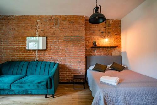 a room with a couch and a bed and a brick wall at Cozy Studio 5 minut by Warsaw East in Warsaw