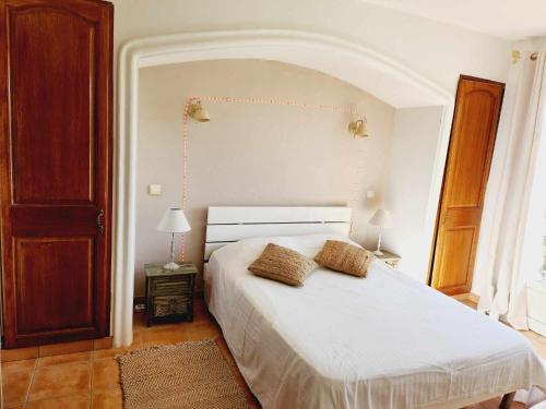 une chambre avec un lit blanc avec deux oreillers dessus dans l'établissement villa en pleine nature, au Muy