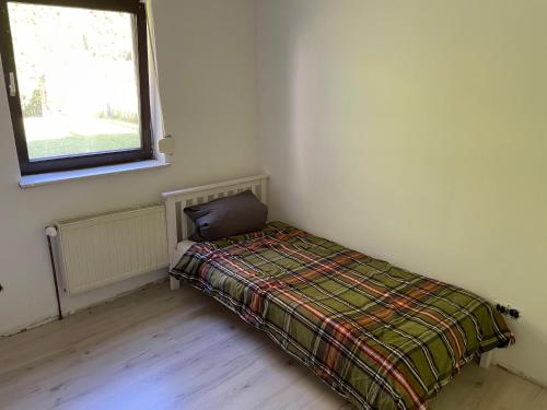 um quarto com uma cama com um cobertor e uma janela em Wohnung mit Garten und überdachter Terrasse em Bremen