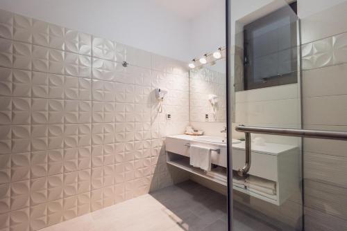 La salle de bains blanche est pourvue d'un lavabo et d'un miroir. dans l'établissement Villa Galleria, à Colibiţa
