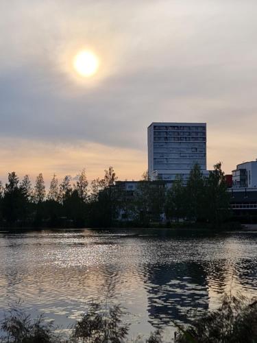a sunset over a body of water with a building at Tower Cabin in Tampere