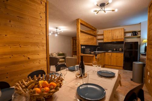 - une salle à manger avec une table et un bol de fruits dans l'établissement Peclet Appartements VTI, à Val Thorens