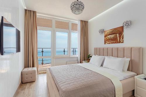 a bedroom with a bed with a view of the ocean at Direct sea view in Odesa