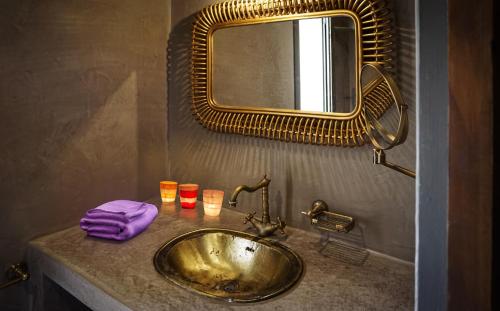 baño con lavabo de oro y espejo en Menzel MARHABA, en Taguermess
