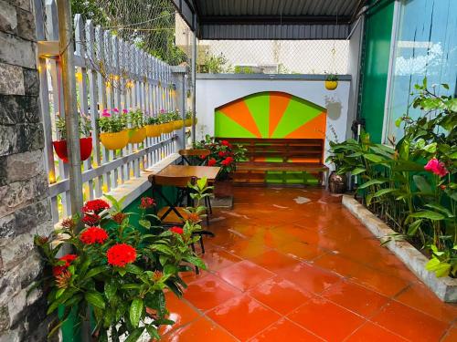un patio con un banco y flores y plantas en Lion HOMESTAY en Ninh Binh