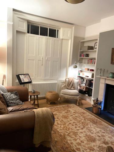 a living room with a couch and a chair and a fireplace at 2 Bedroom Garden Flat /Kings Cross, Central London in London
