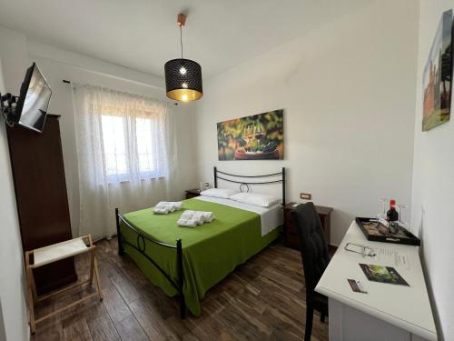 a bedroom with a green bed and a desk at B & B Vigna Di Filippo - Paestum in Paestum