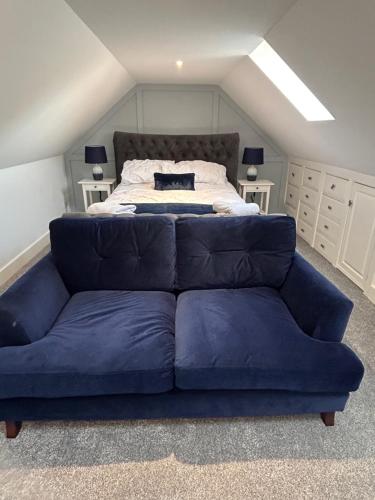 a blue couch in a room with a bed at The Loft and The Den Apartments in Sandown