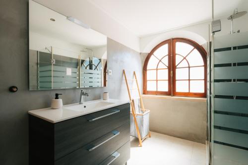 a bathroom with a sink and a window at Alfaiate Beach House in Santa Cruz