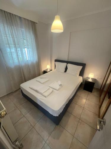 Schlafzimmer mit einem Bett mit weißer Bettwäsche und Kissen in der Unterkunft The traveler's house in Thessaloniki