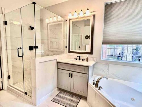 a bathroom with a tub and a sink and a shower at Woodlands Grand 3BR Cozy House in The Woodlands