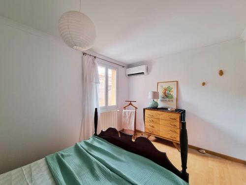 Un dormitorio con una cama verde y una ventana en La Planque/Terrasse - entre Nîmes/Pont du Gard, en Marguerittes