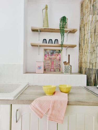 une cuisine avec 2 bols jaunes sur un comptoir dans l'établissement La Planque/Terrasse - entre Nîmes/Pont du Gard, à Marguerittes