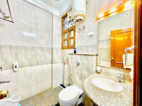 a bathroom with a white toilet and a sink at BedChambers Serviced Apartments - Artemis Hospital in Gurgaon