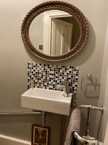 a bathroom with a white sink and a mirror at 2 Bedroom Garden Flat /Kings Cross, Central London in London