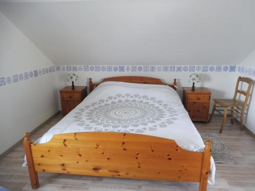 a bedroom with a wooden bed and two chairs at La Lustinoise in Lustin