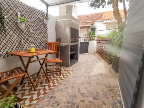 eine kleine Terrasse mit einem Holztisch und Stühlen in der Unterkunft Cantinho da Susana in Coimbra