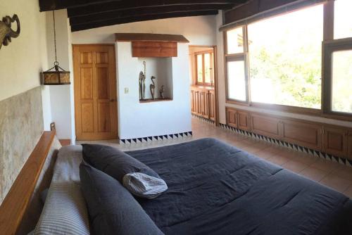 迪坡斯特蘭的住宿－Acogedora Villa con alberca climatizada en el centro de Tepoztlán，一间卧室设有一张大床和一个大窗户