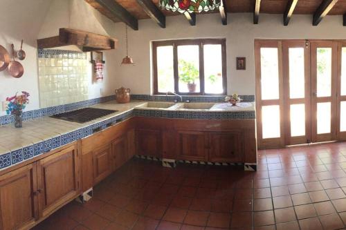 Acogedora Villa con alberca climatizada en el centro de Tepoztlán في تيبوزتلان: مطبخ بدولاب خشبي ومغسلة