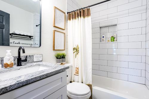 biała łazienka z umywalką i toaletą w obiekcie Living in a Greenhouse - City Retreat - 3BR with 70 inches TV w mieście Farmers Branch
