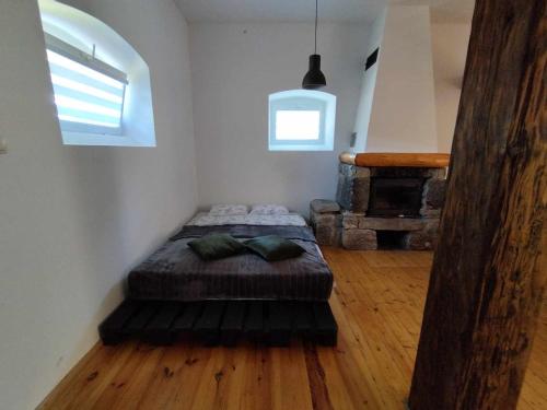 a bedroom with a bed in the corner of a room at Apartament - Stara Stajnia - Na krańcu Świata in Miłków