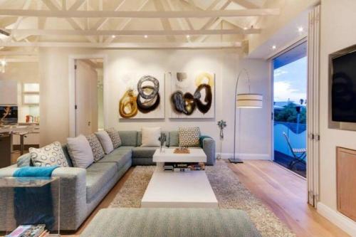 a living room with a couch and a table at Clifton 4th Villa in Cape Town