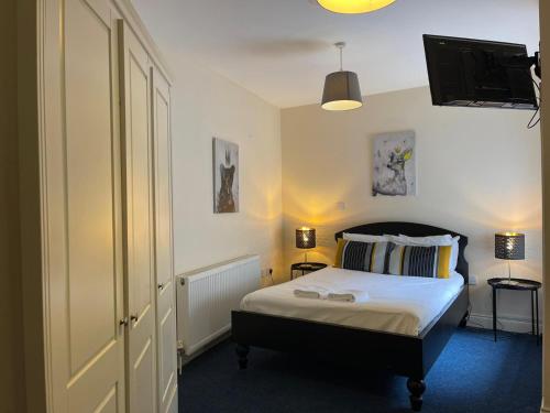 a bedroom with a bed and a tv on the wall at King's Cross Quiet Apartment in London
